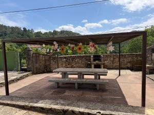 Ein Picknicktisch vor einer Steinmauer mit Blumen in der Unterkunft Casa Goris in Merza