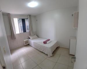 a small bedroom with a bed and a window at Cantinho da Deusa in São José de Ribamar