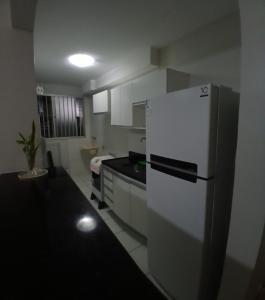 a kitchen with a white refrigerator and a sink at Cantinho da Deusa in São José de Ribamar