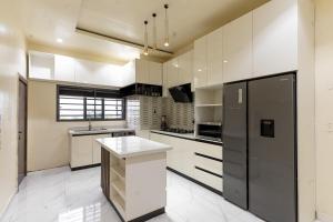 a kitchen with white cabinets and a black refrigerator at Mirage in Lekki