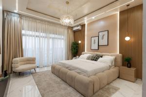 a large bedroom with a large bed and a chair at Mirage in Lekki +16 photos