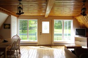 - un salon avec une table à manger et des fenêtres dans l'établissement Chalet du barrage, à East Broughton Station