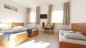 a hotel room with two beds and a desk at Baltic Resort - Korsarz in Darłowo