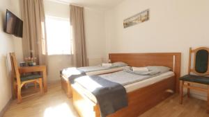 a bedroom with two beds and a chair at Baltic Resort - Korsarz in Darłowo