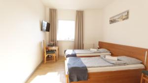 a bedroom with two beds and a window at Baltic Resort - Korsarz in Darłowo +3 photos