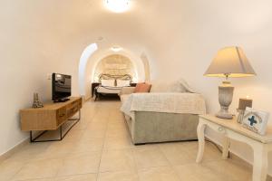 a bedroom with a bed and a tv and a table at Archontiko Koufantonis in Kotronas