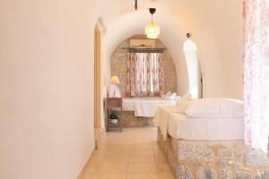 a bedroom with two beds and a window at Archontiko Koufantonis in Kotronas