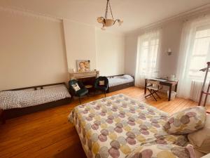 a bedroom with a bed and a desk in it at Chambres Senta Fe in Sainte-Foy-la-Grande