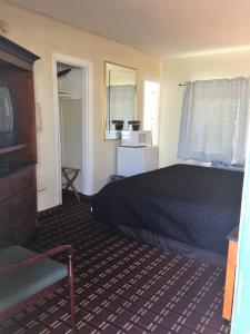 a hotel room with a bed and a television at Vacation Inn Motel in Fort Lauderdale