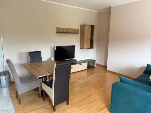 a living room with a dining room table with a television at Apartmani Ljupko in Pančevo