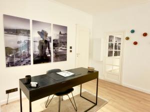 a black desk in a white room with paintings on the wall at Luxury Elegance Comfort 3-room apartment of 80m2 with 2 BDR 2 BA 3 min Croisette & Beach in Cannes