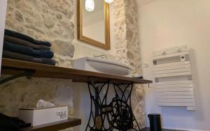 a bathroom with a sink and a mirror on the wall at La Caminada Vielha in Montaillou