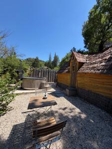 a patio with a wooden table and a building at La cabane escagassée in Grambois