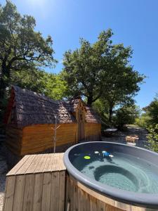 a hot tub on a wooden deck with a house at La cabane escagassée in Grambois