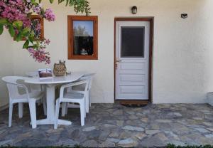 a white table and chairs next to a white door at Νέος Πύργος Family Home in Neos Pirgos +49 photos