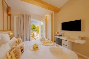 a living room with a white couch and a television at Lou Saint-Tropez in Saint-Tropez