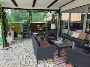a patio with couches and chairs and a table at vila darkoni in Bijeljina