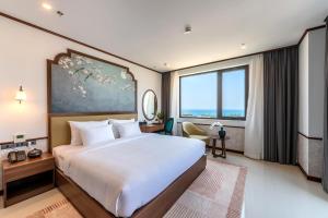 a bedroom with a large bed and a large window at Grand Luxury Hotel Ninh Chử in Thôn Mỹ Phước