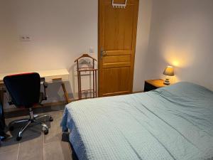 a bedroom with a bed and a desk and a chair at Logis Sol Levante in Arles-sur-Tech