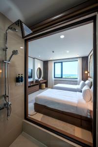 a bedroom with a large bed and a shower at Grand Luxury Hotel Ninh Chử in Thôn Mỹ Phước