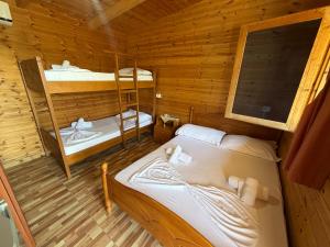 a room with two beds in a log cabin at Blue Marli Rooms in Himare