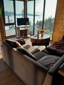 a living room with a large couch and a television at GomisMta-Luxury Cottage with Panor in Gomi