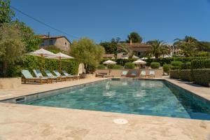 a swimming pool with chairs and umbrellas at Lou Saint-Tropez in Saint-Tropez