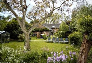a garden with chairs and a house at Sterrenbos wellness lodge in Beers