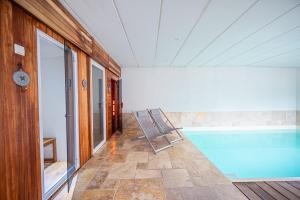 a swimming pool in a room with a house at Les Gîtes de Sprimont - Le Cosy in Sprimont