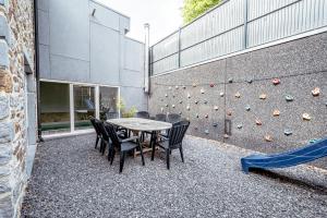 a table and chairs in front of a climbing wall at Les Gîtes de Sprimont - Le Cosy in Sprimont
