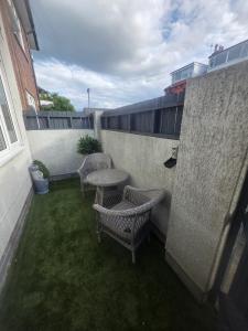a patio with three chairs and a table on a building at Harehills House in Killingbeck