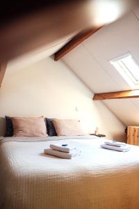 a bedroom with a large bed with two towels on it at Sterrenbos wellness lodge in Beers