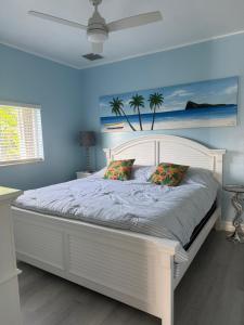 a white bed in a bedroom with a blue wall at Villa Bremen - Pool / Spa Home in Cape Coral +37 photos
