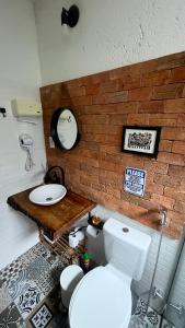 a bathroom with a white toilet and a sink at Chalés Calima in Lençóis +9 photos