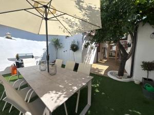a table and chairs with an umbrella in a yard at La Casa de Célia in Valencia de Don Juan