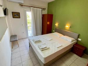 a bedroom with a bed and a green wall at Hotel Evagelia in Leptokarya