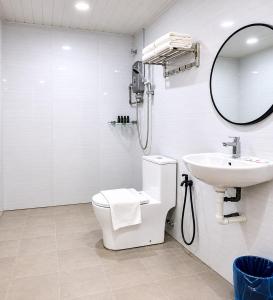 a bathroom with a sink and a toilet and a mirror at SS Hotel Seremban in Seremban