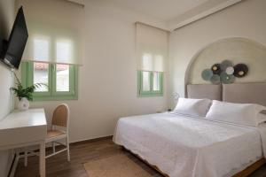 a bedroom with a bed and a desk and windows at Pnoe Luxury Villa - Private Pool Retreat & BBQ in Ierissos +43 photos