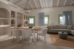 a living room with a table and chairs and a couch at Pnoe Luxury Villa - Private Pool Retreat & BBQ in Ierissos