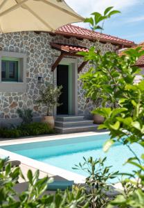 a villa with a swimming pool in front of a house at Pnoe Luxury Villa - Private Pool Retreat & BBQ in Ierissos