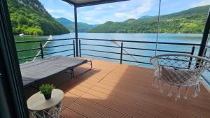 a balcony of a boat with a swing and a table at Splav Rio in Aluga