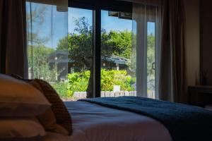 a bedroom with a bed and a large window at Retreat 1 in Beccles