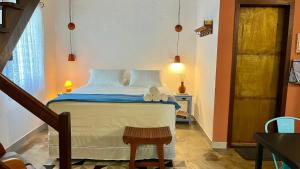 a bedroom with a bed with blue and white sheets at Chalés Calima in Lençóis