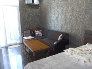 a living room with a couch and a table and two beds at batumi orbi sea tawers in Batumi +4 photos