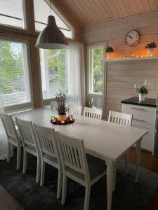 a dining room with a white table and white chairs at Genuine Beach House and Sauna in Pello +23 photos