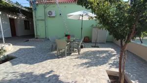a patio with a table and chairs and an umbrella at Antonia's house on the beach in Skala Sotiros +33 photos