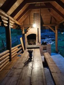 a large room with a fireplace in a wooden building at Pensiunea Larix in Răchiţele