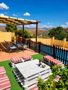 a patio with a table and chairs and a fence at Cortijo Molino los Justos in Fuentes de Cesna