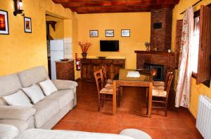 a living room with a couch and a table and a fireplace at Cortijo Molino los Justos in Fuentes de Cesna