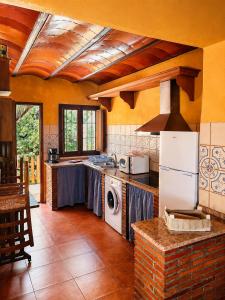 a kitchen with a stove and a washer and dryer at Cortijo Molino los Justos in Fuentes de Cesna